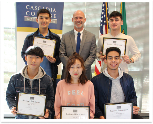 Students hold their framed scholarship certificates